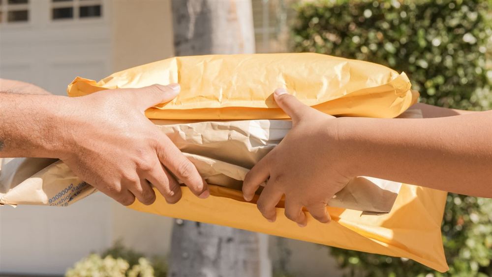 Dos personas intercambiando paquetes en una entrega